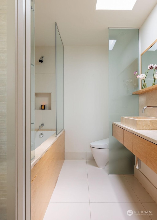 full bathroom featuring tile patterned flooring, vanity, toilet, and a skylight