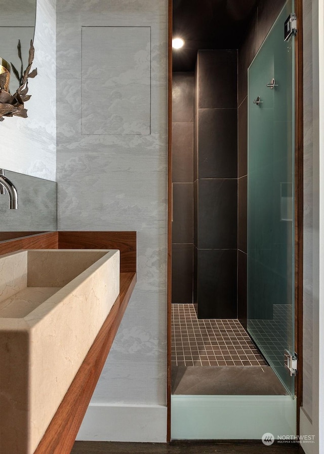 bathroom featuring a tile shower and sink