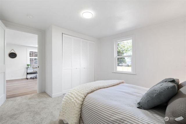 bedroom with light colored carpet and a closet