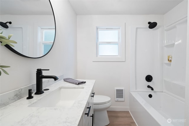 full bathroom featuring vanity, hardwood / wood-style flooring, toilet, and washtub / shower combination