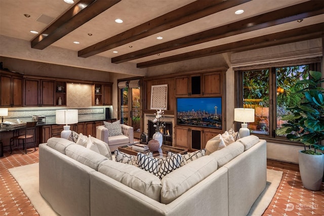 living room featuring beam ceiling and a premium fireplace