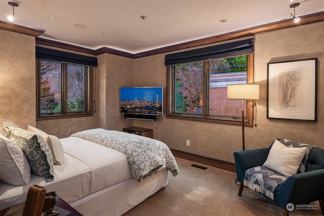 bedroom with crown molding and carpet flooring