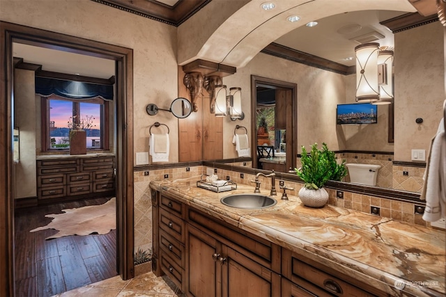 bathroom with tile walls, crown molding, and vanity