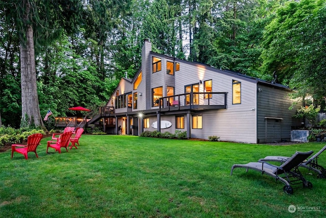 rear view of property with a yard and a balcony