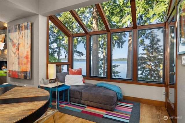 sunroom / solarium with a water view and a fireplace