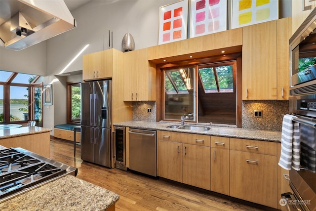 kitchen featuring appliances with stainless steel finishes, backsplash, extractor fan, beverage cooler, and sink