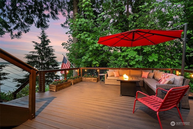 deck at dusk featuring an outdoor living space with a fire pit