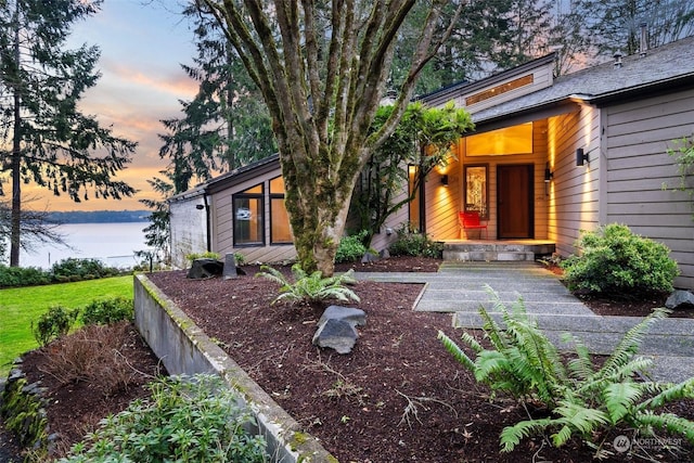 exterior entry at dusk with a water view