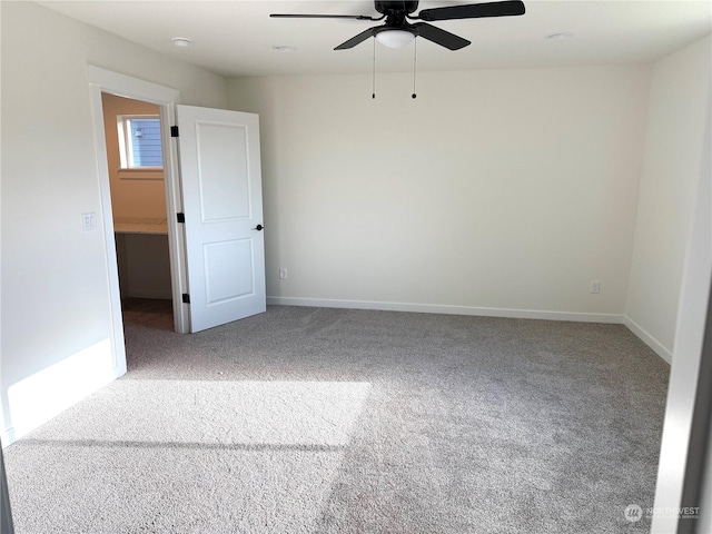 carpeted spare room with ceiling fan