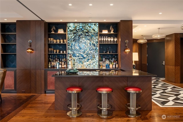 bar featuring wood-type flooring and built in shelves