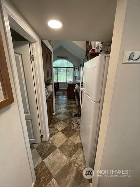 kitchen with white refrigerator and vaulted ceiling