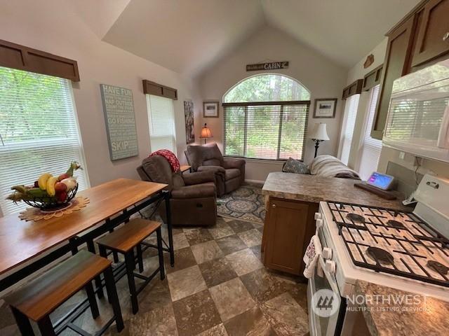 kitchen featuring vaulted ceiling and white appliances