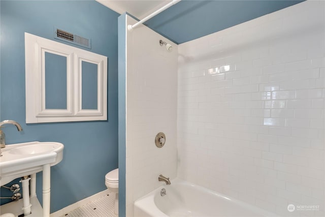 bathroom featuring tile patterned floors, toilet, and tiled shower / bath