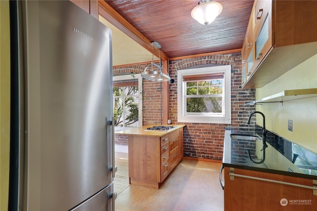 kitchen featuring decorative light fixtures, wood ceiling, stainless steel appliances, and brick wall