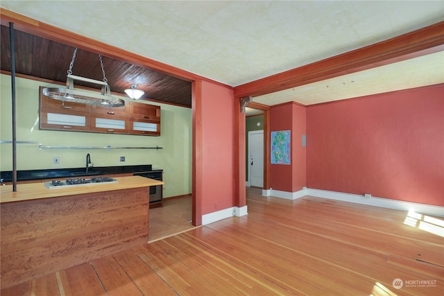 kitchen with light hardwood / wood-style flooring, stainless steel gas cooktop, and wood ceiling