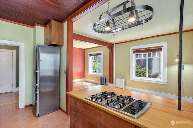 kitchen featuring pendant lighting, radiator heating unit, stainless steel appliances, and wooden ceiling