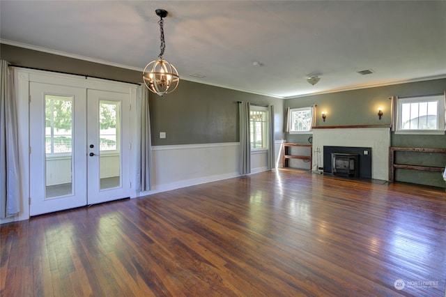 unfurnished living room with a notable chandelier, french doors, dark hardwood / wood-style floors, and crown molding