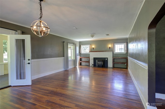 unfurnished living room featuring dark hardwood / wood-style flooring, crown molding, and a chandelier