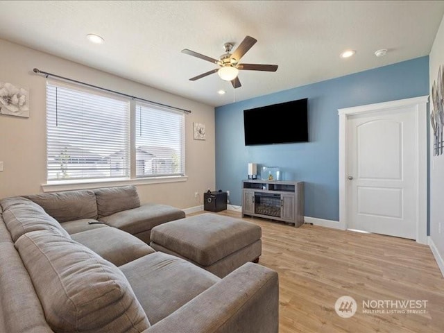 living room with ceiling fan and light hardwood / wood-style flooring