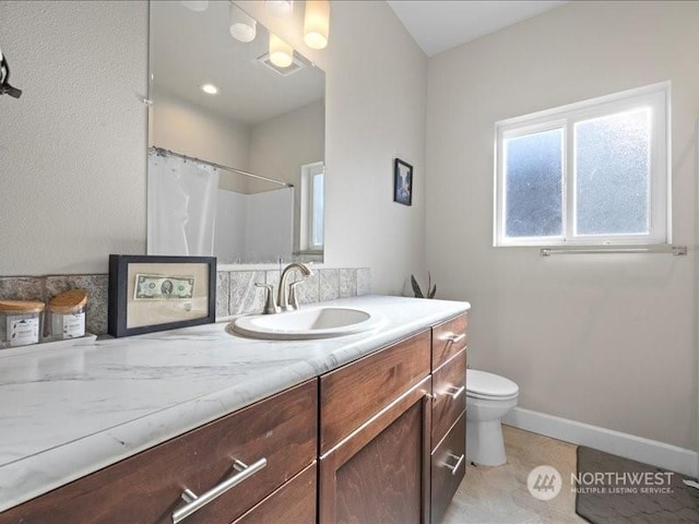 bathroom featuring vanity, curtained shower, and toilet