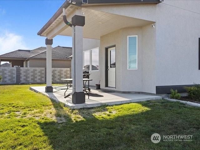 back of house with a patio and a lawn