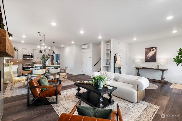 living room with an inviting chandelier, dark hardwood / wood-style floors, and an AC wall unit