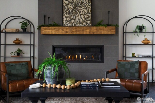 sitting room featuring a tiled fireplace