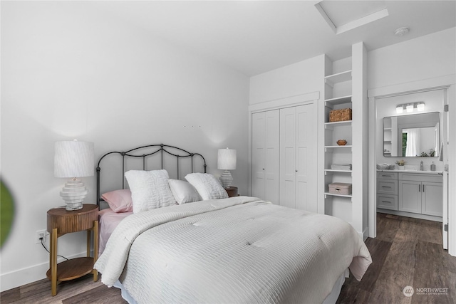 bedroom featuring ensuite bathroom, a closet, dark wood-type flooring, and sink