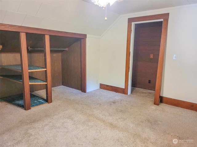 unfurnished bedroom featuring light carpet and lofted ceiling