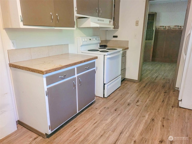 kitchen featuring tile countertops, gray cabinets, light hardwood / wood-style floors, and white appliances