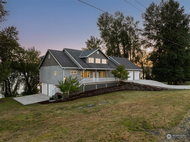 view of front of home featuring a porch, a garage, and a yard