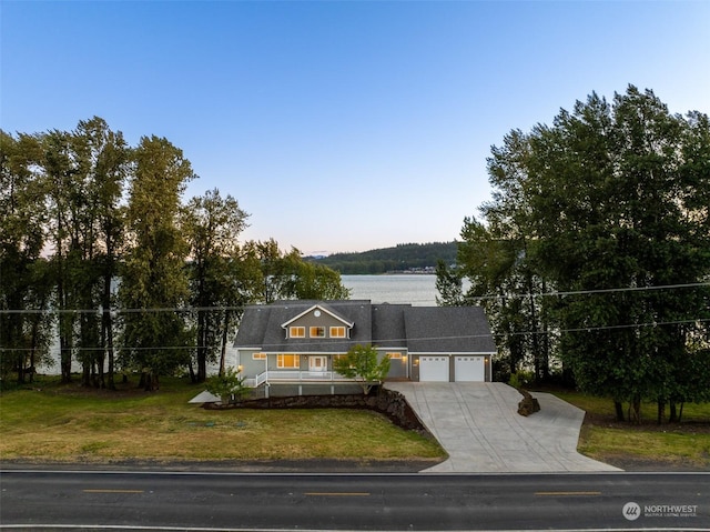 view of front of home featuring a garage, a water view, and a front yard