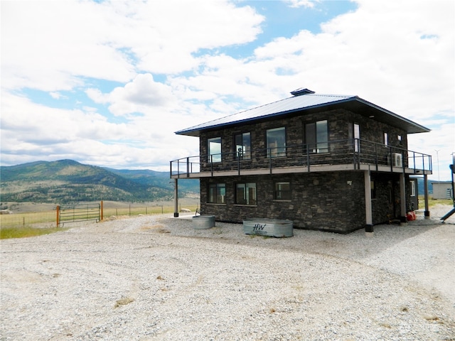 view of front of house featuring a balcony and a mountain view