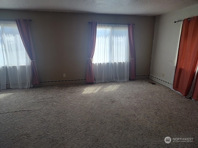 empty room with a textured ceiling, baseboard heating, and carpet