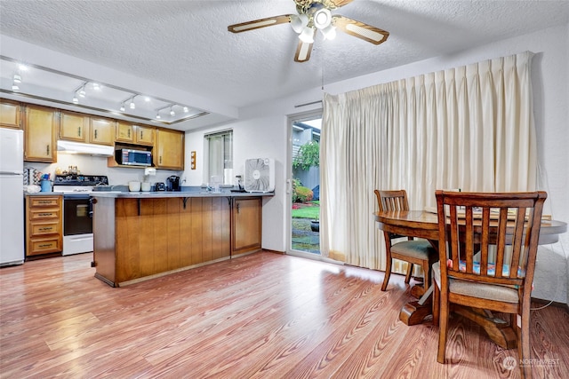 kitchen with white appliances, kitchen peninsula, rail lighting, light wood-type flooring, and ceiling fan