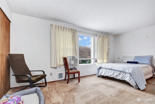 bedroom with light carpet and a textured ceiling