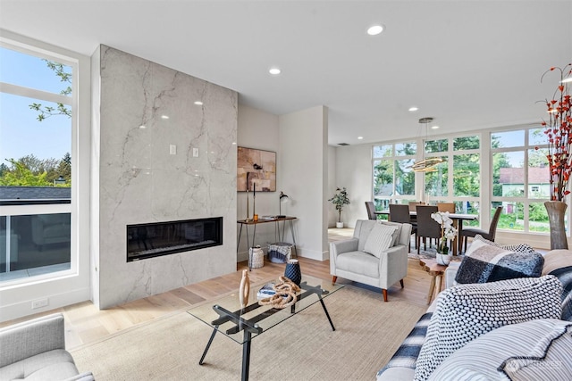 living room featuring a high end fireplace and light hardwood / wood-style floors