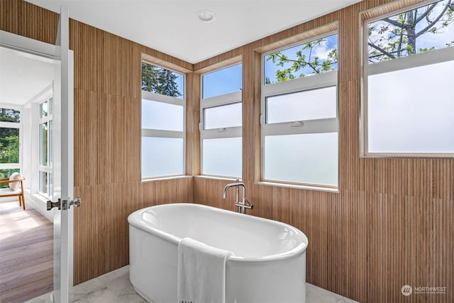 bathroom featuring a tub to relax in and a wealth of natural light