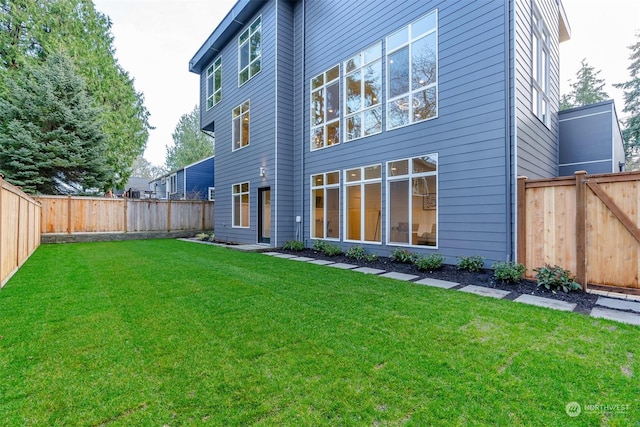 back of house featuring a lawn