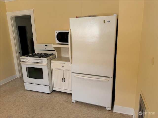 kitchen featuring white appliances and light colored carpet