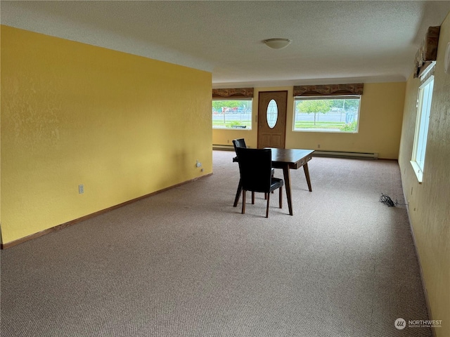 unfurnished dining area with carpet, a textured ceiling, and baseboard heating