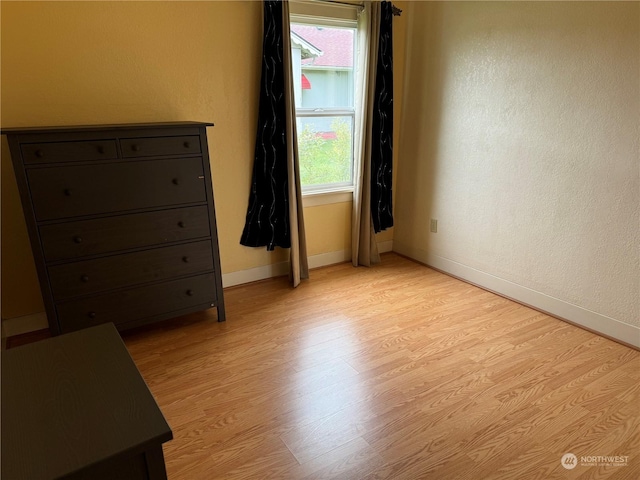 unfurnished bedroom featuring multiple windows and light wood-type flooring