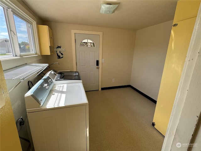 laundry room with washing machine and clothes dryer and cabinets