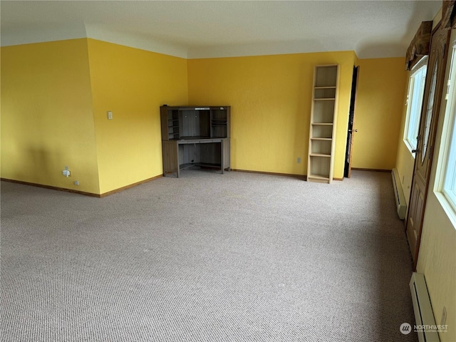 carpeted empty room featuring baseboard heating