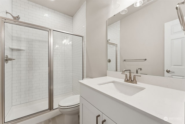 bathroom with an enclosed shower, toilet, and vanity