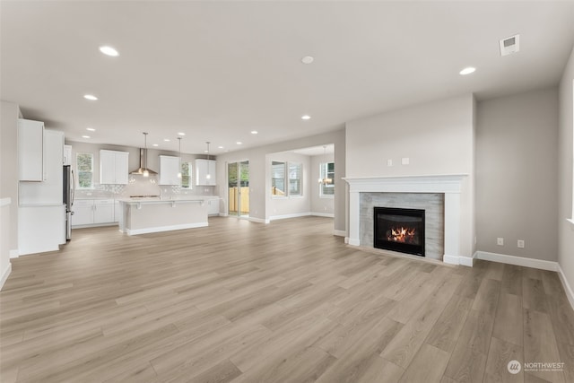 unfurnished living room with plenty of natural light and light hardwood / wood-style floors