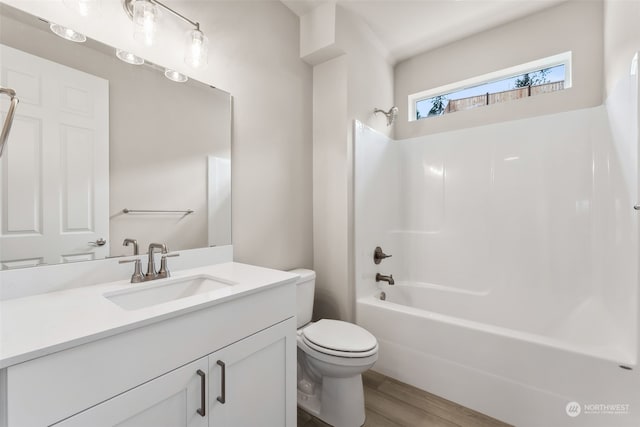 full bathroom with bathing tub / shower combination, wood-type flooring, vanity, and toilet