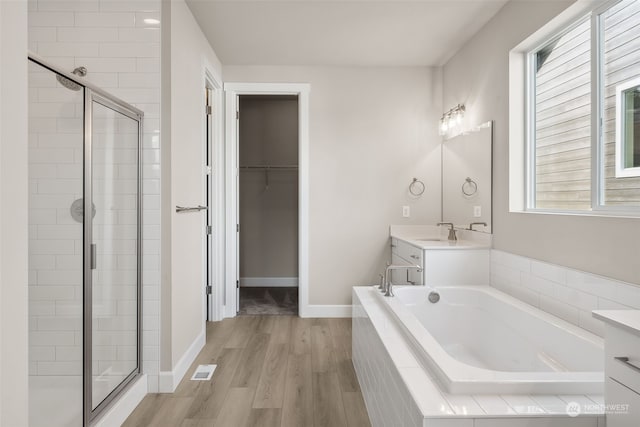 bathroom with separate shower and tub, hardwood / wood-style flooring, and vanity