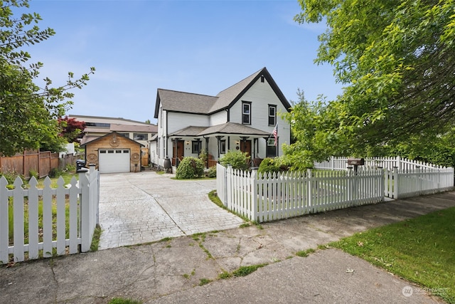 view of front of home featuring a garage and an outbuilding