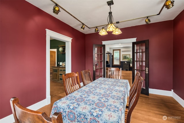 dining area featuring a wall mounted AC and light hardwood / wood-style flooring